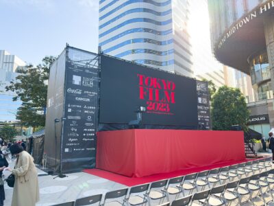 Sponsor-lined stage of the Tokyo International Film Festival at Tokyo Midtown Hibiya, with a red-carpeted platform and rows of chairs