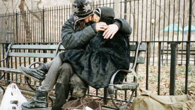 Two people huddled in an embrace on a New York park bench in a still from Josh and Benny Safdie's Heaven Knows What