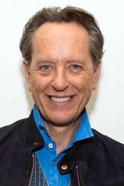 Richard E. Grant als Sir James Catton