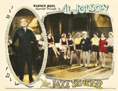 Lobby card for The Jazz Singer showing Al Jolson on stage and with a group of chorus dancers