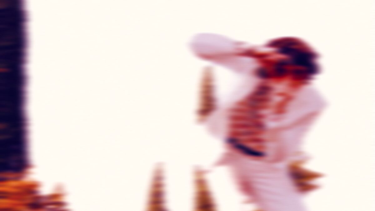 Motion-blurred promotional image of Albert Feiler in a white suit dancing between cypress trees