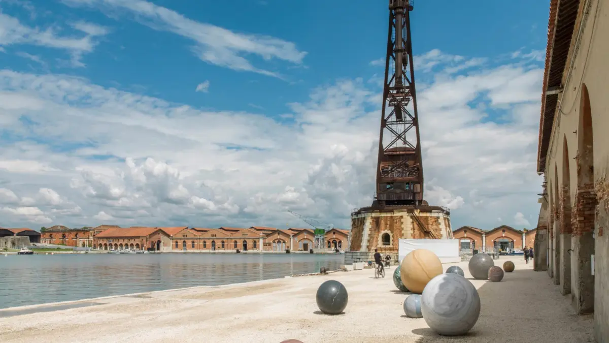 Stone spheres of different sizes scattered along the Arsenale quay in Venice, a sculpture by Alicja Kwade
