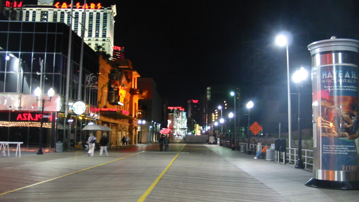 The Atlantic City Boardwalk at night with casino signs lit up