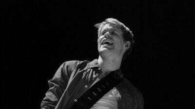 Chord Overstreet singing with a guitar on stage during the Glee Live tour, June 2011