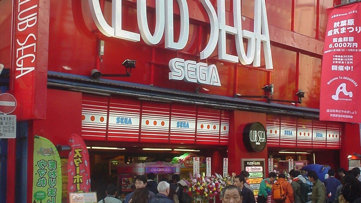 Red facade of the Club SEGA arcade in Akihabara, Tokyo, with pedestrians on the street