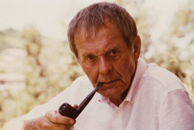 Swiss journalist and collector Eric A. Peschler with a pipe, looking at the camera