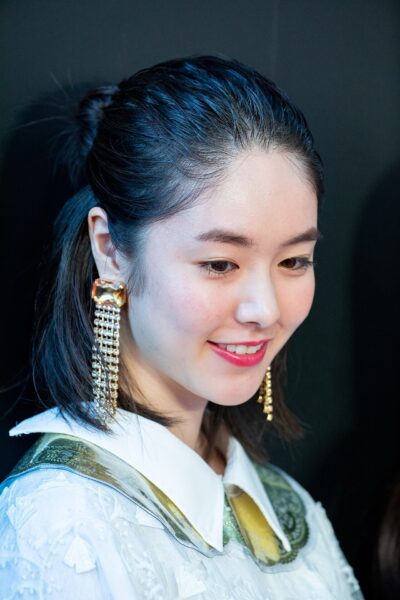 Erika Karata smiling in a white embroidered collar and long crystal earrings on the red carpet of the Tokyo International Film Festival opening ceremony