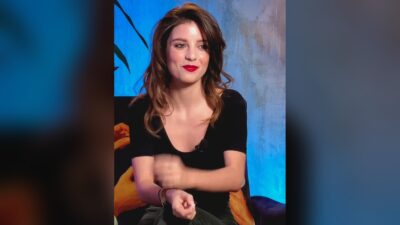 Ginevra Francesconi smiling during a 2024 video interview with Déluge, wearing a black top against a blue painted backdrop