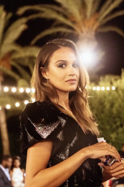 Holly Mae Brood on the set of Love Island at night, in a black sequined dress under palm trees