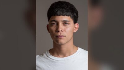 Studio portrait of Mexican actor Juan Daniel García Treviño in a white T-shirt against a grey backdrop