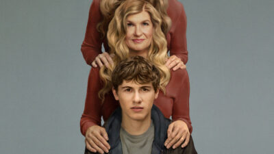 Phony key art with Connie Britton standing behind Sam Nivola, two pairs of hands resting on his shoulders against a grey backdrop
