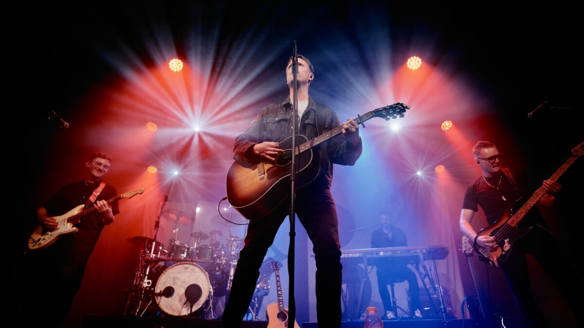 Kasper Buch and his band on stage under red and blue concert lights