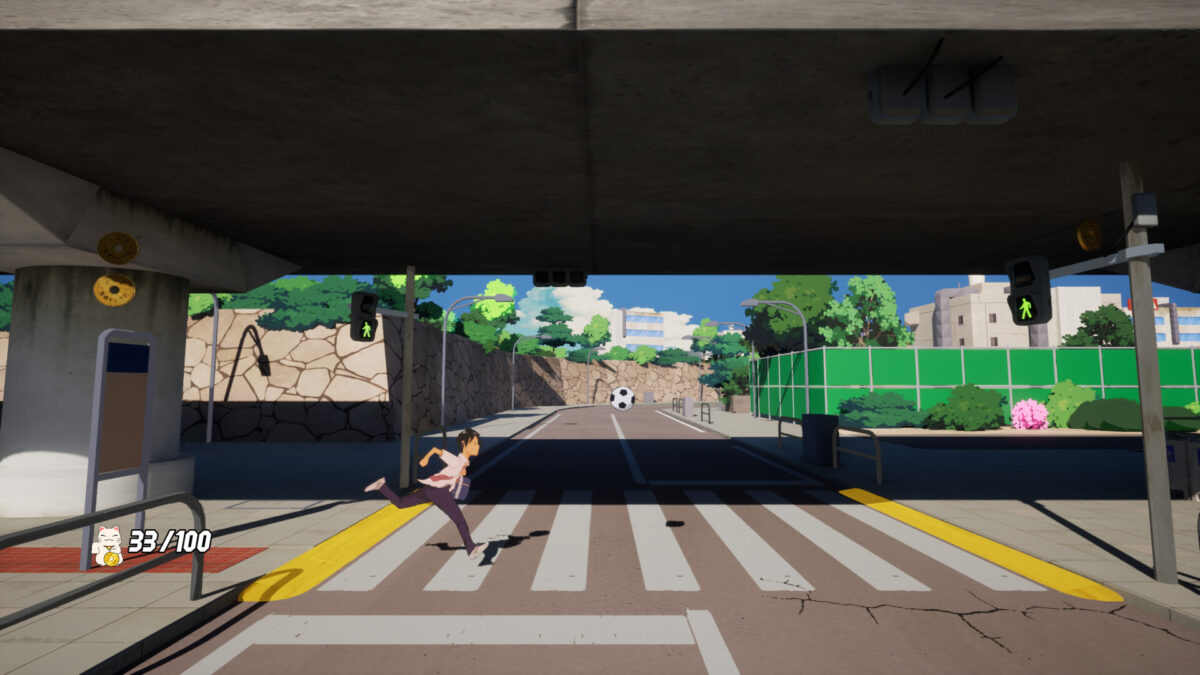 The Kid sprints across a zebra crossing beneath an overpass chasing a soccer ball in Kick