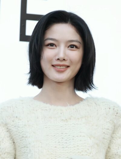 Kim You-jung smiling in a white knit sweater at a CLANE photocall, September 2026
