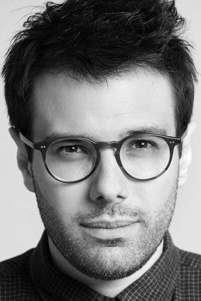 Black-and-white portrait of Brazilian filmmaker Matheus Souza wearing round glasses