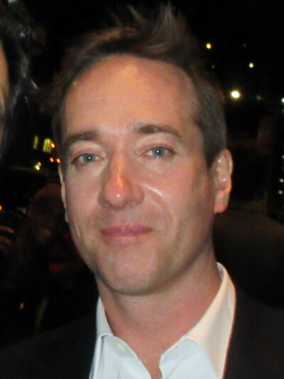 Matthew Macfadyen in a dark jacket and white open-collar shirt outside a New York theatre at night, April 2019