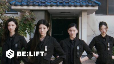 The four promoting members of ILLIT in black agent suits outside a tiled-roof building in the You're Under Arrest music video