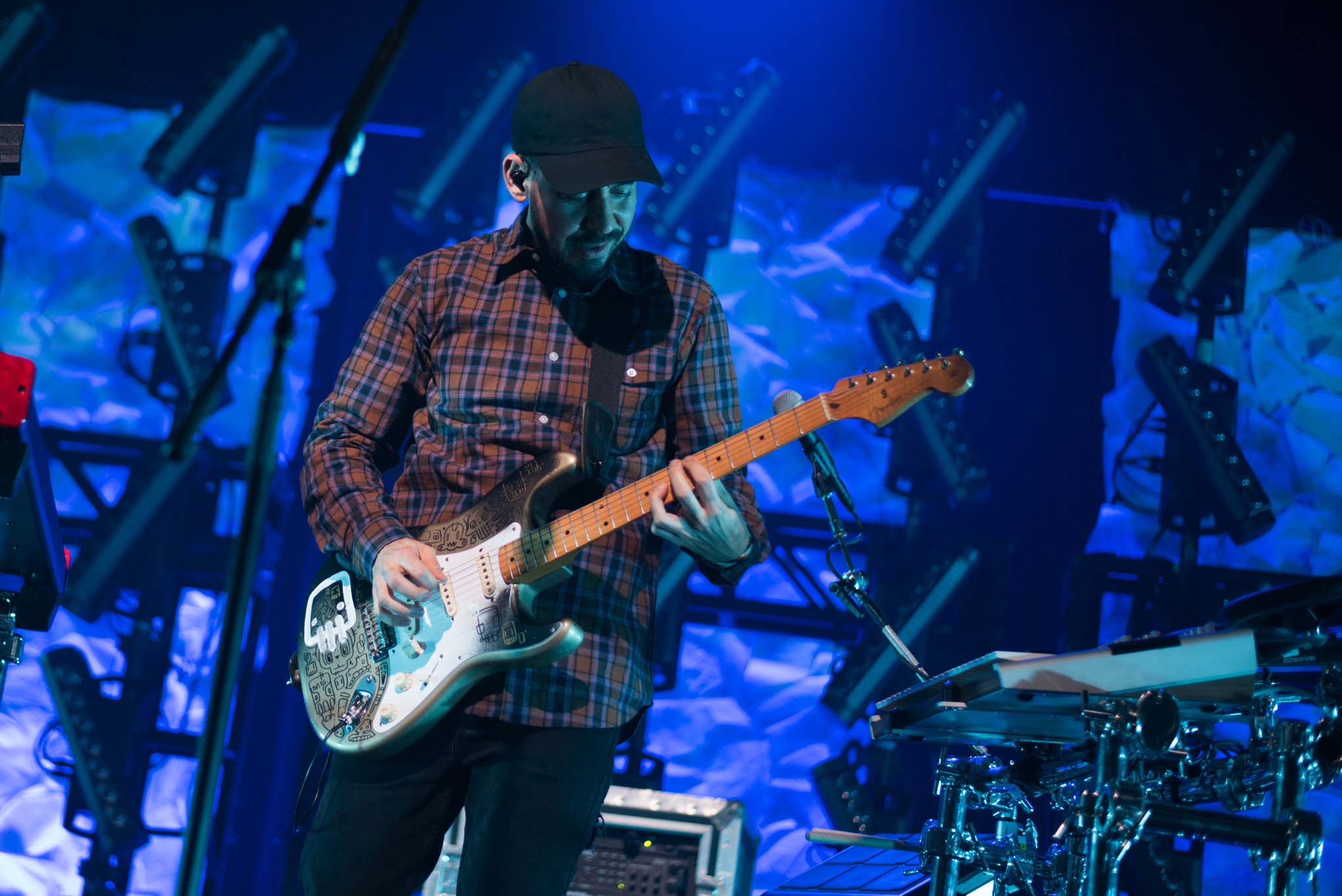 Mike Shinoda playing an electric guitar on stage at the House of Blues in Boston in 2018