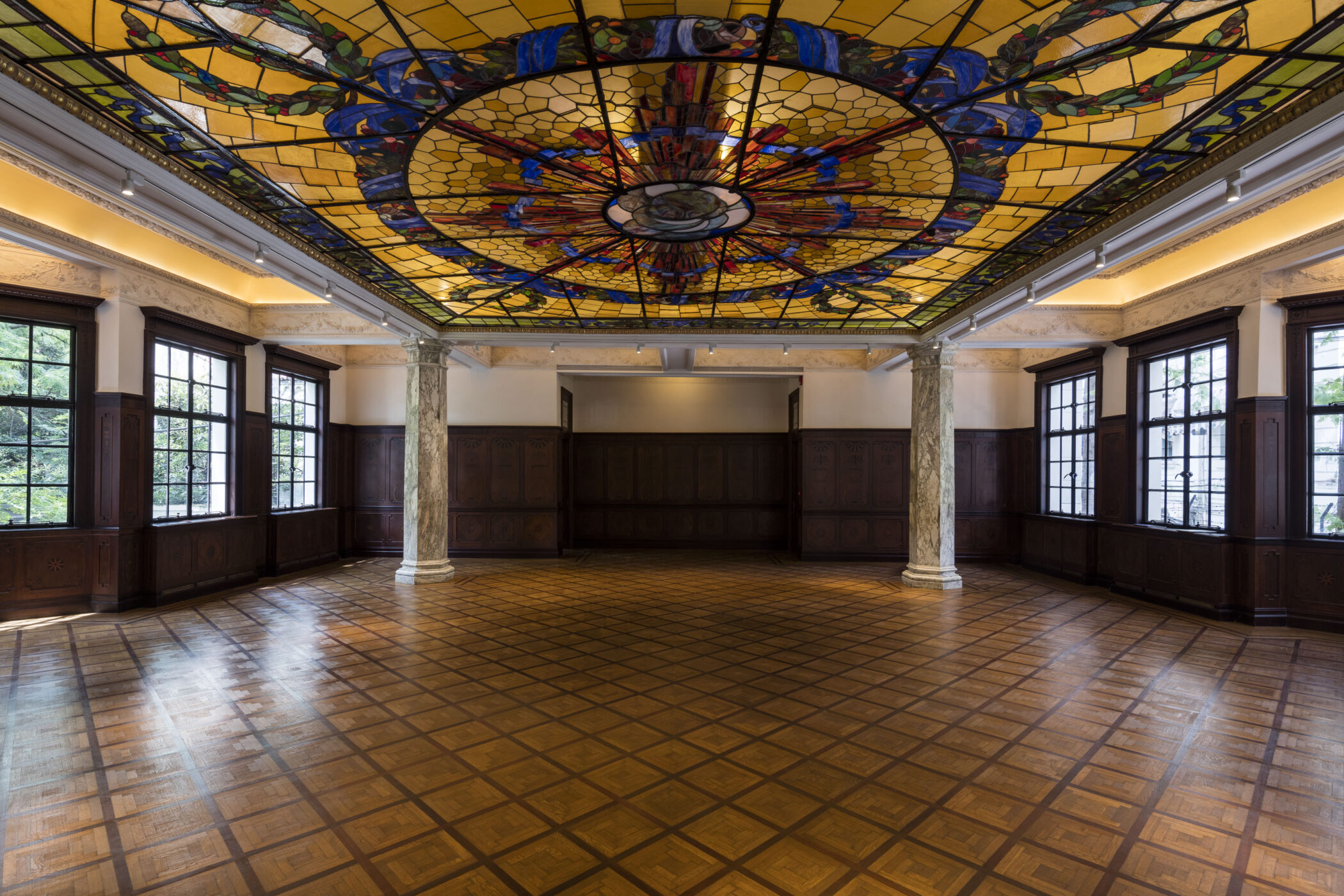 The Ballroom of Prada Rong Zhai in Shanghai, with its stained-glass skylight, wood-panelled walls and patterned parquet floor