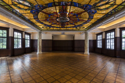 The Ballroom of Prada Rong Zhai in Shanghai, with its stained-glass skylight, wood-panelled walls and patterned parquet floor