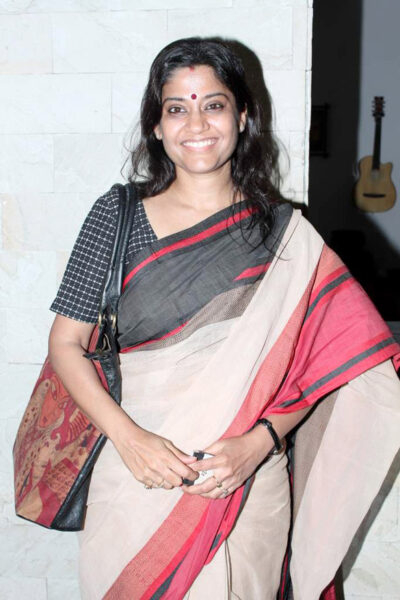 Renuka Shahane smiling in a red-bordered cotton sari at the Kashish film festival press meet in Mumbai, 2012
