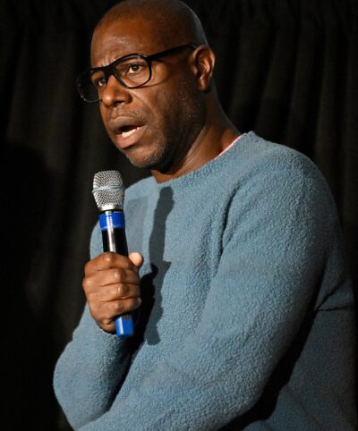 British film director and artist Steve McQueen speaking into a microphone at the Middleburg Film Festival, October 2024