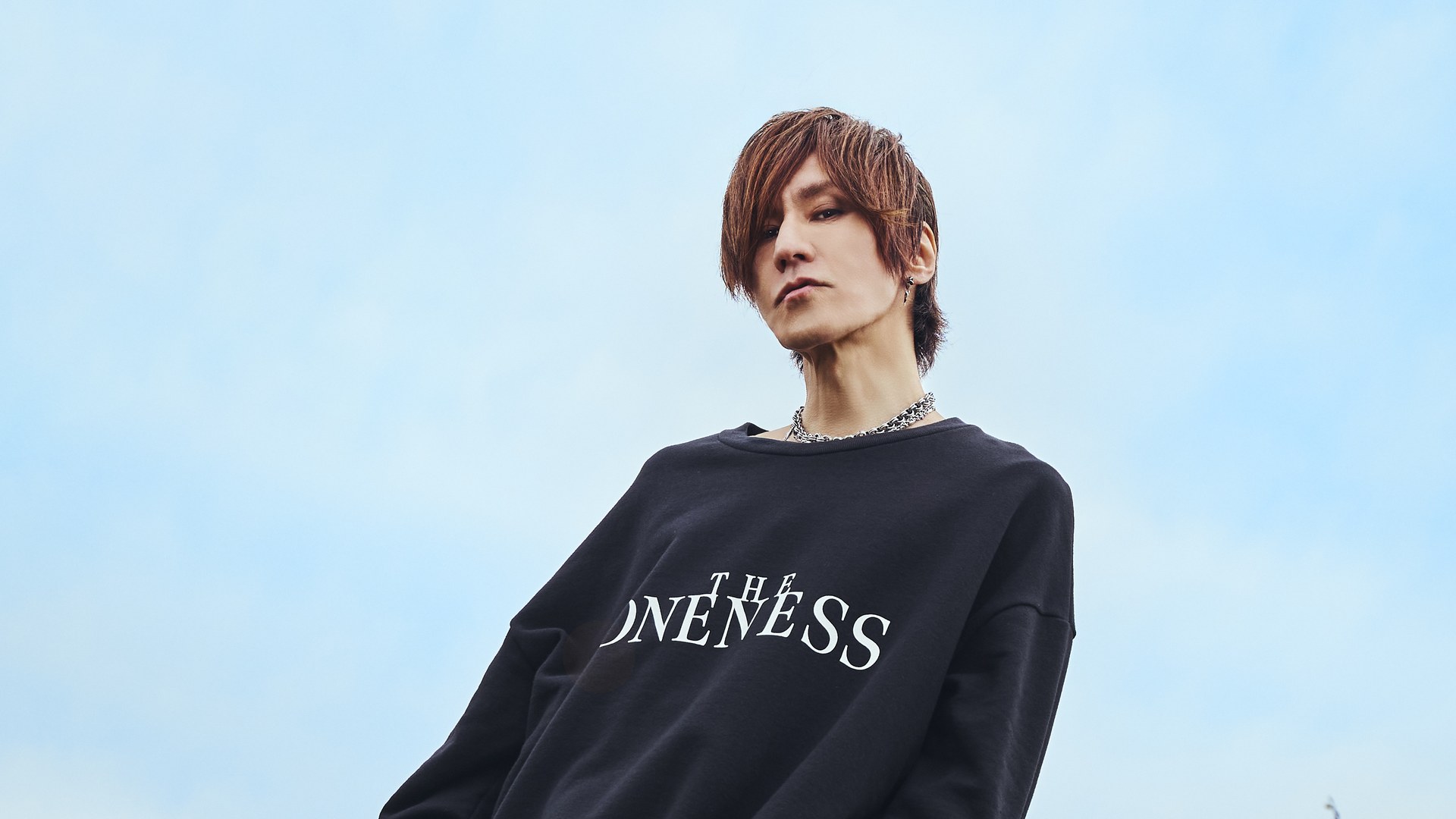 Sugizo, guitarist of Luna Sea and X Japan, in a black sweatshirt against a pale sky