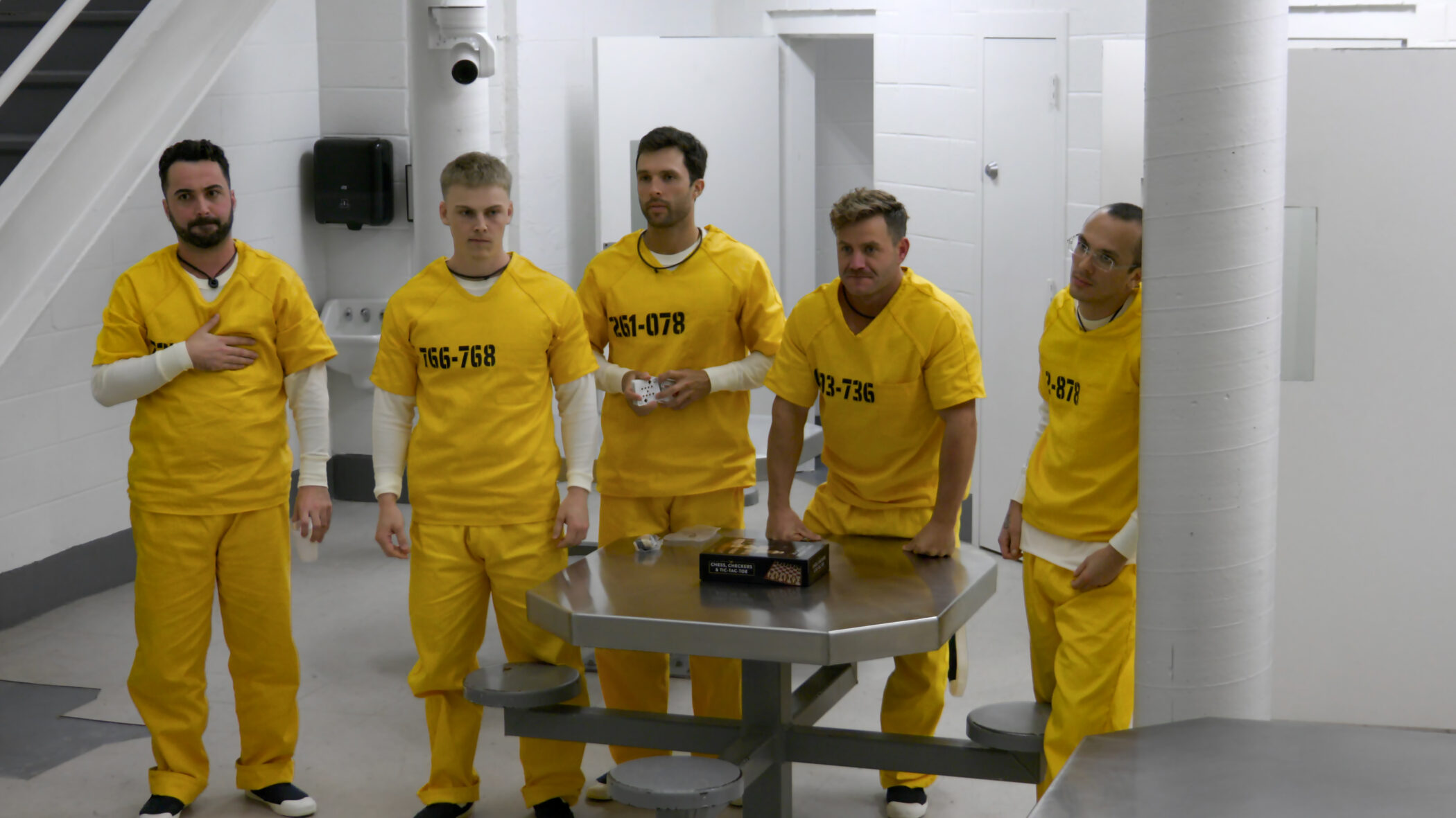 Participants in yellow prison jumpsuits in a cell block in the Netflix series The New Stanford Prison Experiment