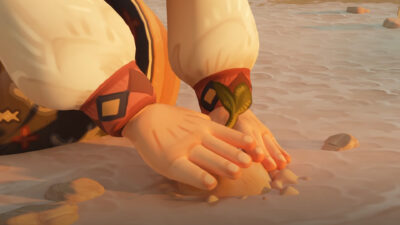 Hands pressing a green sprout into dry sand in The Regreening