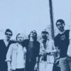Very Old Morris band members standing by a utility pole in San Antonio