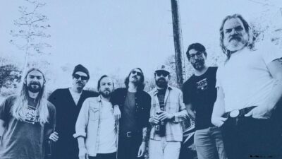Very Old Morris band members standing by a utility pole in San Antonio