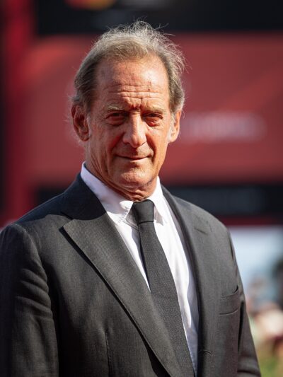 Vincent Lindon in a dark suit and tie on the red carpet at the 81st Venice International Film Festival, 2024