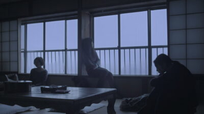 Still from Hiroshi Ishikawa's Petal Dance (2013): three women in a dim, blue-lit Japanese inn room by tall windows