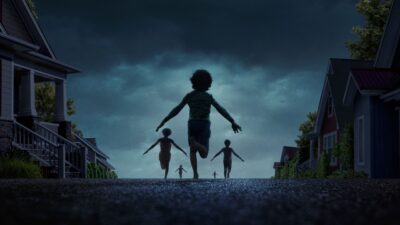 Children running down a suburban street at night in Weapons
