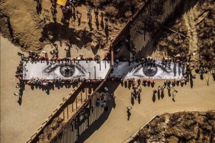 JR (French, born 1983). Migrants, Mayra, Picnic across the Border, Tecate, Mexico—U.S.A., 2017. Installation image. Wheat-pasted poster on table. © JR-ART.NET