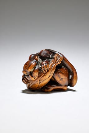 a wood netsuke of a tiger eating a bamboo shoot by Matsuda Sukenaga, Takayama, Hida Province, early 19th century sold five times its estimate for €51,900.